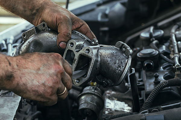 dirty, greasy hands of a man repairing the engine, EGR valve, cl dirty, greasy hands of a man repairing the engine, EGR valve, close up.